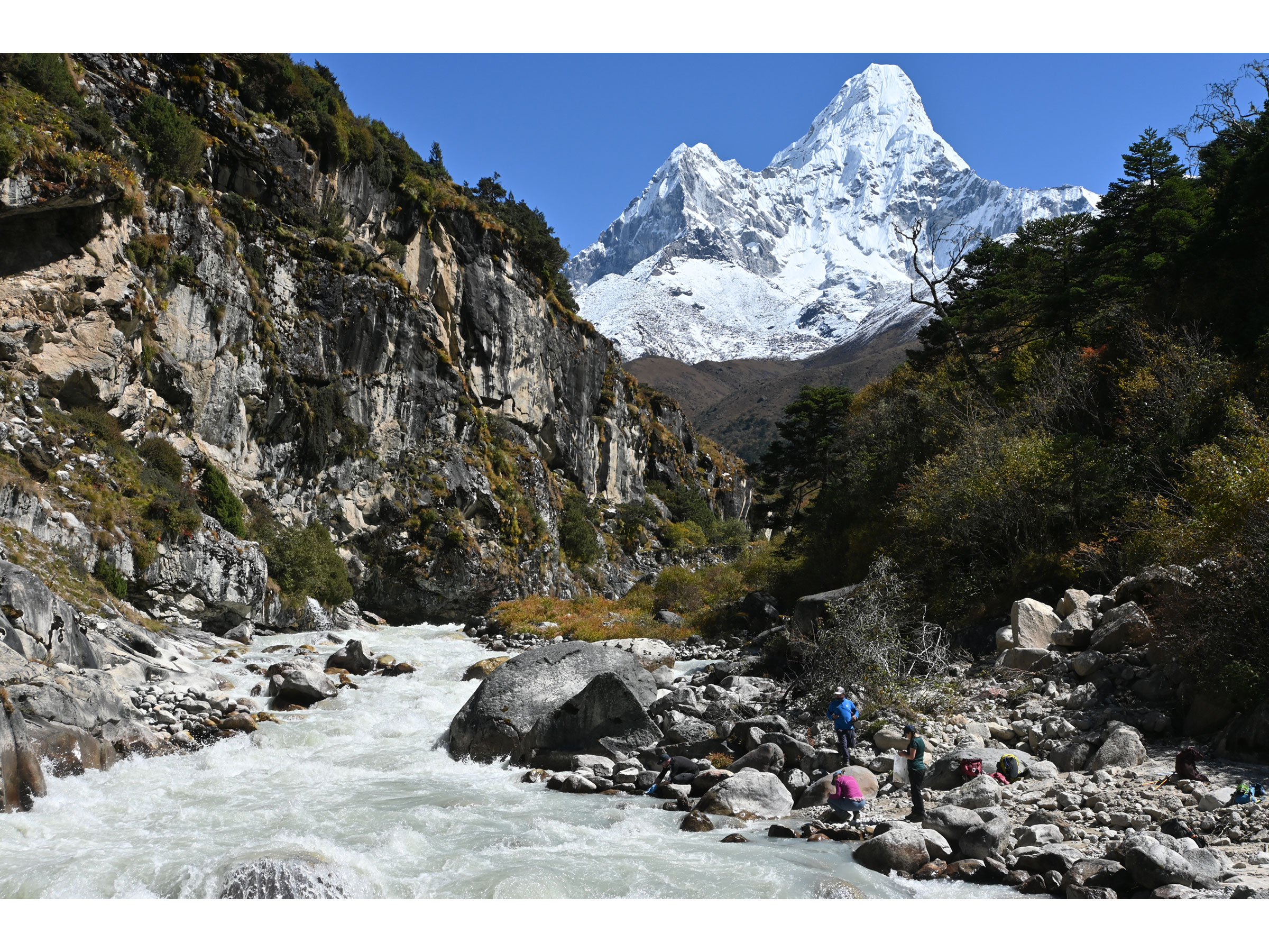 researchers working beside a stream in the himalayas
