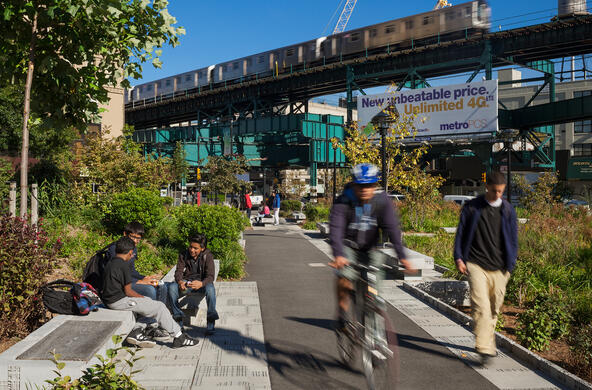 urban environment with plants, bicyclist, walkers, public transit